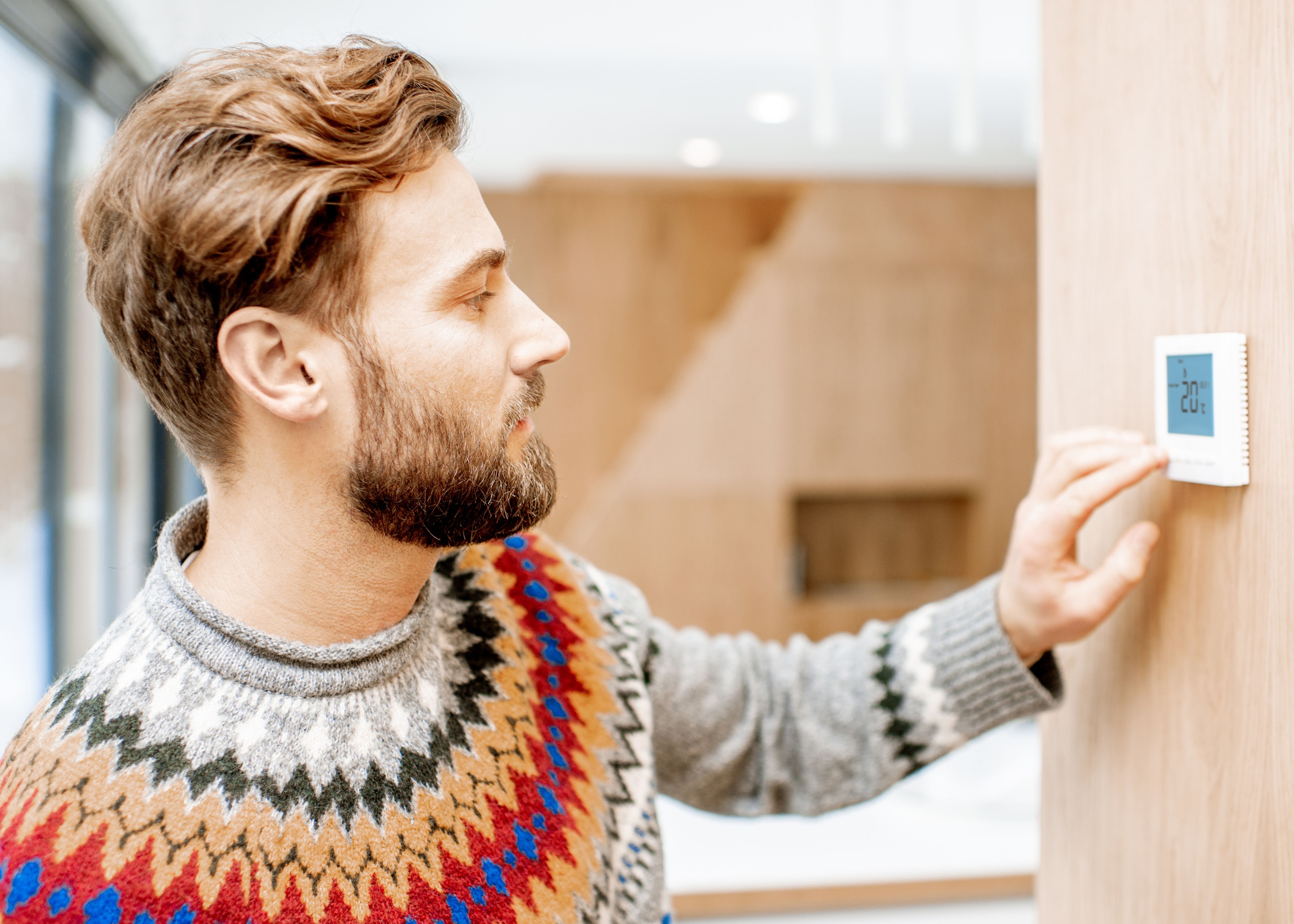 Man adjusting thermostat